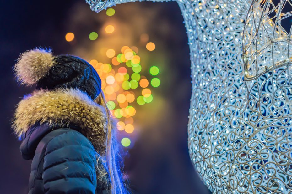 Girl in winter coat looks at Christmas lights - Free Christmas Lights YYC