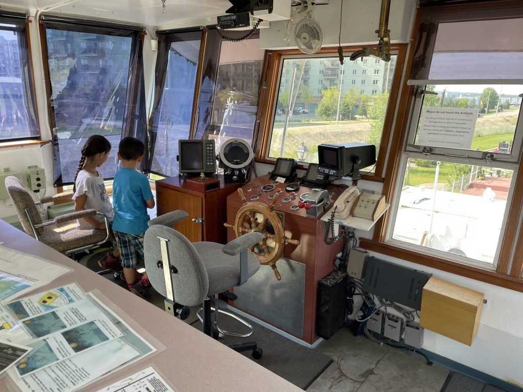 Kids on the ship bridge in The Shipyard Museum in Fort McMurray